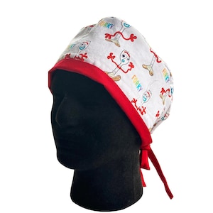 May include: White surgical scrub cap with a red trim and ties. The cap is patterned with the character Forky from Toy Story, with the word "Forky" in various colors. The cap is on a black mannequin head.