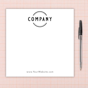 Könnte beinhalten: Ein weißer Notizblock mit dem Wort "COMPANY" in einem schwarzen kreisförmigen Logo oben. Die Website-Adresse "www.YourWebsite.com" befindet sich unten. Ein schwarzer Stift befindet sich rechts vom Notizblock.