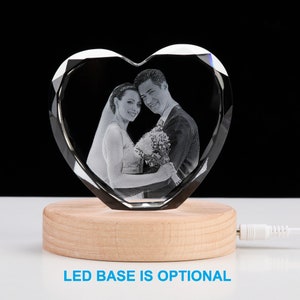 May include: A crystal heart-shaped paperweight with a laser-engraved image of a couple. The paperweight is on a wooden base with an optional LED light.