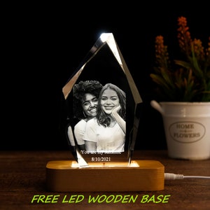 May include: A crystal pyramid with a personalised photo of two women and the text "You are my sunshine 8/10/2021". The crystal is illuminated from below by a wooden base with a built-in LED light.