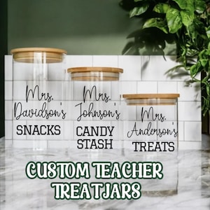 May include: Three glass jars with bamboo lids and custom labels. The labels read "Mrs. Davidson's Snacks", "Mrs. Johnson's Candy Stash", and "Mrs. Anderson's Treats". The jars are labeled "Custom Teacher Treat Jars".