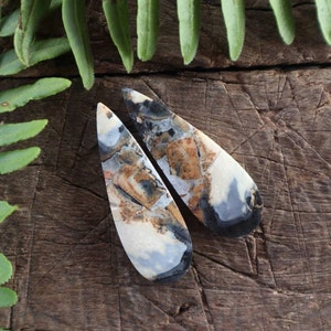 Peut inclure: Une paire de boucles d'oreilles en forme de goutte d'eau en agate blanche, noire et brune. Les boucles d'oreilles sont polies et ont une finition lisse et brillante.