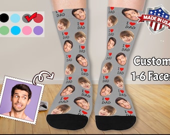 May include: A pair of gray socks with a black toe and heel. The socks feature a repeated pattern of faces and the text "I Love Dad".