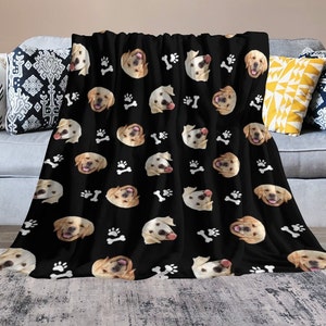 May include: Black fleece throw blanket with a repeating pattern of white paw prints and golden retriever dog faces.