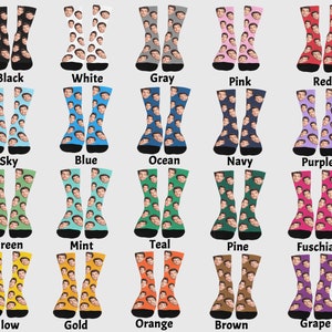 Op de afbeelding: Een set van 20 paar sokken in verschillende kleuren en patronen. Elke sok heeft een herhalend patroon van een gezicht. De kleuren omvatten zwart, wit, grijs, roze, rood, hemelsblauw, blauw, oceaanblauw, donkerblauw, paars, groen, mint, teal, donkergroen, fuchsia, geel, goud, oranje, bruin en druif.