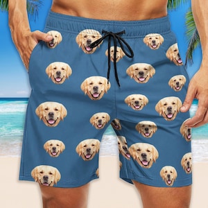 May include: Blue swimming trunks with a pattern of golden retriever dog faces.