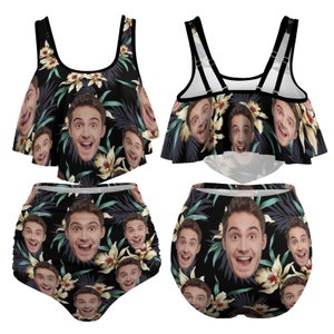 K&ouml;nnte beinhalten: Ein schwarzer Bikini mit einem Blumendruck, der ein sich wiederholendes Muster eines menschlichen Gesichts zeigt. Das Bikinioberteil hat einen R&uuml;schenrand und das Unterteil ist hoch tailliert.