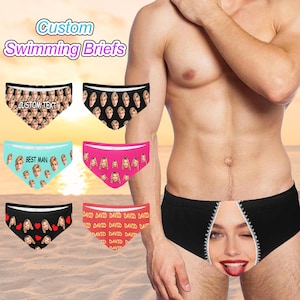 Puede incluir: Se muestran varios calzoncillos de natación personalizados, cada uno con una impresión fotográfica única. Los calzoncillos están disponibles en varios colores, incluyendo negro, rosa y azul, con texto como "CUSTOM TEXT" y "BEST MAN". También se ve un calzoncillo negro con un diseño de cremallera.