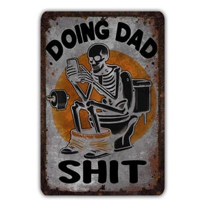 May include: A rectangular metal sign with a distressed, rusty appearance. The sign features a skeleton on a toilet, engrossed in a phone. The words "DOING DAD SHIT" are printed in bold, black letters. An orange circle is behind the skeleton.