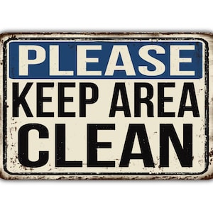 Può includere: Un cartello in metallo in stile vintage con un aspetto usurato e arrugginito. Il cartello ha uno sfondo bianco con testo blu e nero che dice "PLEASE KEEP AREA CLEAN".