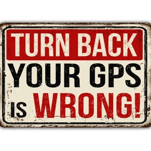 May include: A vintage-style metal sign with a distressed, rusty look. The sign has a red background with white text that reads "TURN BACK YOUR GPS IS WRONG!"