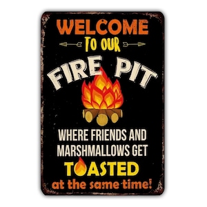 May include: A black metal sign with a rusty texture. The sign reads "Welcome to our Fire Pit Where friends and marshmallows get toasted at the same time!" with a drawing of a campfire.