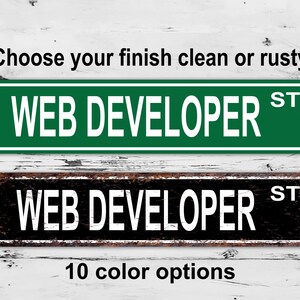Può includere: Due cartelli stradali con la scritta "WEB DEVELOPER ST". Un cartello è verde con lettere bianche, l'altro è nero con un bordo arrugginito e lettere bianche. È presente anche il testo "Scegli la tua finitura pulita o arrugginita" e "10 opzioni di colore".