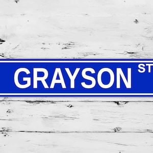 May include: Blue street sign with white text that reads "GRAYSON ST".