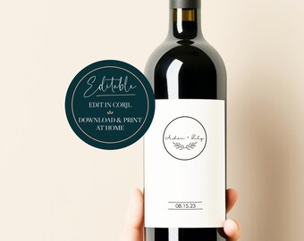 May include: Editable wine bottle label with a dark blue circle and white text that says "Editable, Edit in Corjl, Download & Print at Home". The label on the bottle has a white background with a black circle and the text "Arden & Lily" with a small branch design. The date "08.15.23" is printed below the circle.