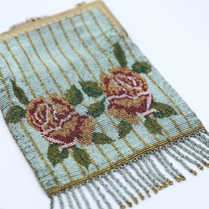 Peut inclure: Un sac &agrave; main vintage en perles avec un fond ray&eacute; bleu et or et deux roses rouges et jaunes. Le sac &agrave; main a un fermoir en m&eacute;tal et une frange de perles.