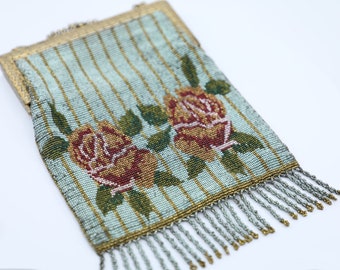May include: A vintage beaded purse with a blue and gold striped background and two red and yellow roses. The purse has a metal clasp and a fringe of beads.