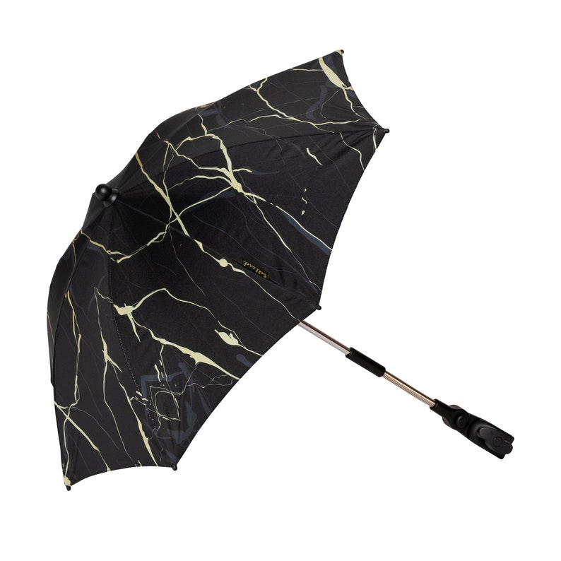May include: Black and gold stroller sunshade with a marble pattern. The sunshade has a black metal frame and a black plastic clip for attaching to a stroller.