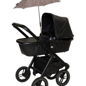 May include: A black stroller with a black leatherette bassinet and a leopard print sunshade. The stroller has four wheels and a storage basket.