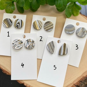 May include: Five sets of earrings with different shapes and patterns. The earrings are made of white, black, and gold marbled clay. The earrings are numbered 1 through 5.