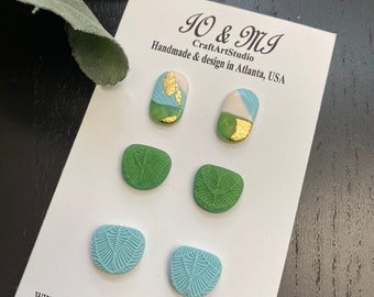 May include: A set of six handmade ceramic earrings in various shades of green and blue with gold accents. The earrings are displayed on a white card with the text "JO & MJ CraftArtStudio Handmade & design in Atlanta, USA www.etsy.com/shop/IoMiCraftArtStudio?ref"
