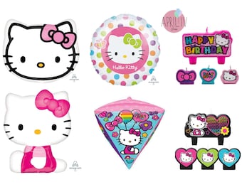 Può includere: Un set di decorazioni per feste di Hello Kitty, che include un palloncino rosa e bianco, un palloncino rosa e bianco con la faccia di Hello Kitty, un palloncino a forma di cono rosa e bianco, una candela rosa e bianca con la scritta "Buon compleanno" su di essa, e un set di tre candele rosa, verde e blu con i volti di Hello Kitty.