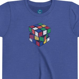 Może przedstawiać: Koszulka w kolorze królewskiego błękitu z vintage'owym, wielokolorowym nadrukiem kostki Rubika.