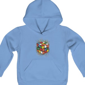 May include: A light blue hooded sweatshirt with a colorful Rubik's Cube graphic on the front. The cube is surrounded by a black and white scribble design.