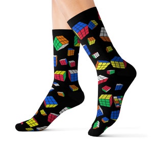 May include: A pair of black socks with a colorful Rubik's Cube pattern. The socks are made of a soft, comfortable material and are perfect for everyday wear.