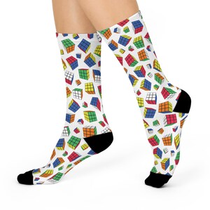 May include: A pair of white socks with a colorful Rubik's Cube pattern. The socks are black at the toe and heel.