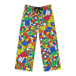 May include: A pair of colorful pajama pants with a pattern of Rubik's Cubes. The pants are white with a variety of colors including red, blue, green, yellow, and orange.