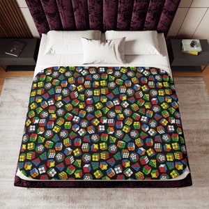 May include: A black and white bedding set with a repeating pattern of colorful Rubik's Cubes. The cubes are arranged in a random pattern and are in various shades of red, blue, green, yellow, orange, and white.