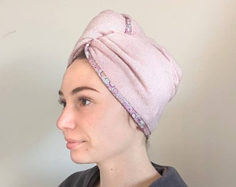 Può includere: Un asciugamano per capelli in microfibra rosa con un bordo a stampa floreale. L'asciugamano è avvolto intorno alla testa di una persona.