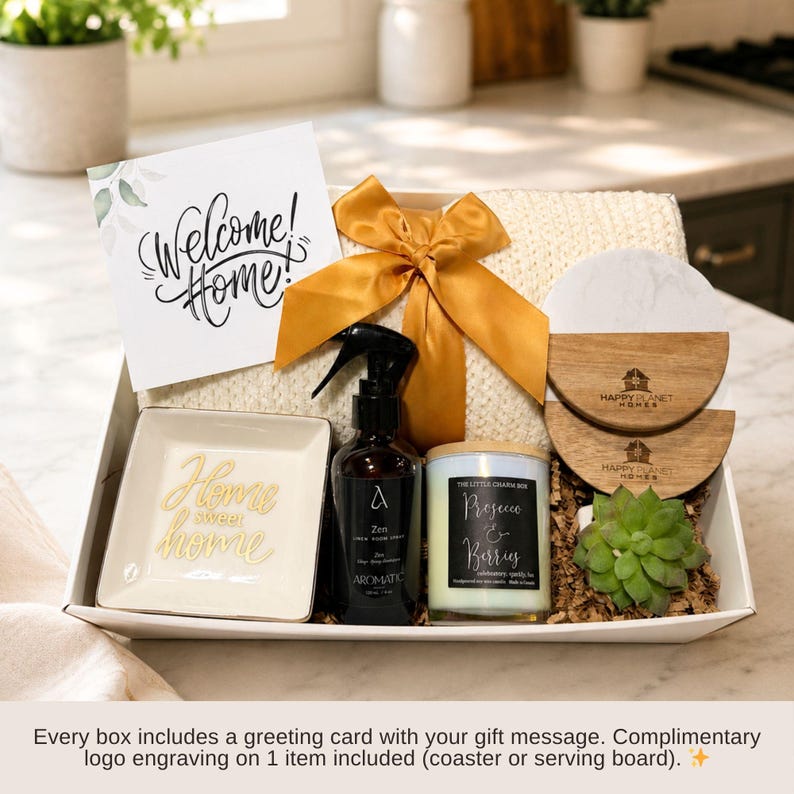 Puede incluir: Una caja de regalo que contiene una tarjeta blanca con el texto Welcome Home, una manta de punto color crema con un lazo dorado, un plato cuadrado blanco con texto dorado Home sweet home, un pulverizador negro, una vela, dos posavasos y una suculenta.