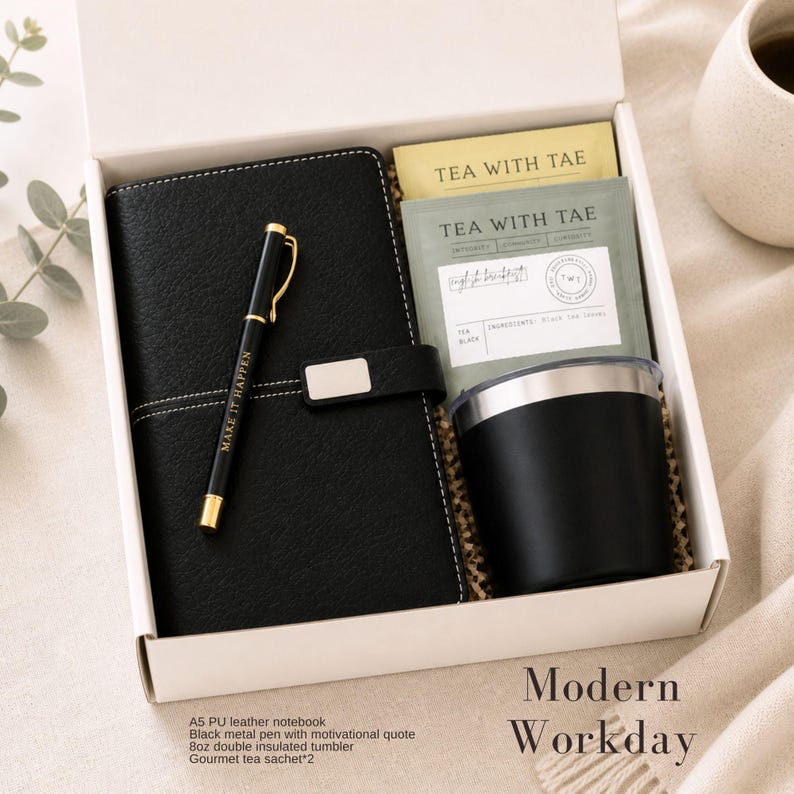 Puede incluir: Una caja de regalo que contiene un cuaderno de cuero PU negro, un bol&iacute;grafo de metal negro con "MAKE IT HAPPEN", un vaso aislado negro de 237 ml y dos bolsitas de t&eacute;. La caja est&aacute; etiquetada como "Modern Workday".