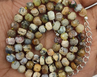 May include: A multi-colored opal gemstone necklace with a silver chain and a silver pendant. The necklace is made of faceted beads and has a variety of colors, including brown, green, white, and red.