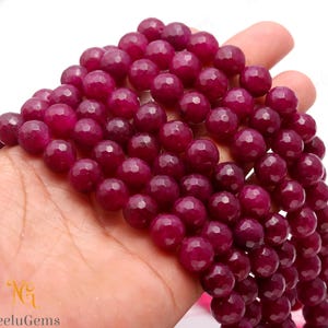 Op de afbeelding: Een streng diep roze facetgeslepen edelsteen kralen. De kralen zijn rond en hebben een gladde, gepolijste afwerking.