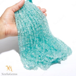 Könnte beinhalten: Eine Strähne aus hellblauen Aquamarin-Edelsteinkugeln. Die Kugeln sind facettiert und haben eine glatte, polierte Oberfläche. Die Kugeln sind auf einem durchsichtigen Faden aufgefädelt und haben einen Durchmesser von etwa 4 mm.