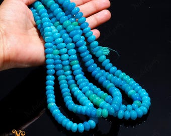 May include: A strand of turquoise blue gemstone beads, with a graduated color effect, strung on a cord. The beads are round and smooth, and the strand is long enough to be worn as a necklace or bracelet.