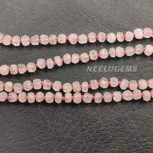 May include: A pink rose quartz gemstone necklace with a silver pendant. The necklace is made of small, faceted beads and is strung on a pink thread.