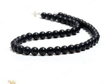 Puede incluir: Un collar de cuentas de ónix negro con cierre de plata. Las cuentas son redondas y lisas, y el collar mide aproximadamente 45 cm de largo.