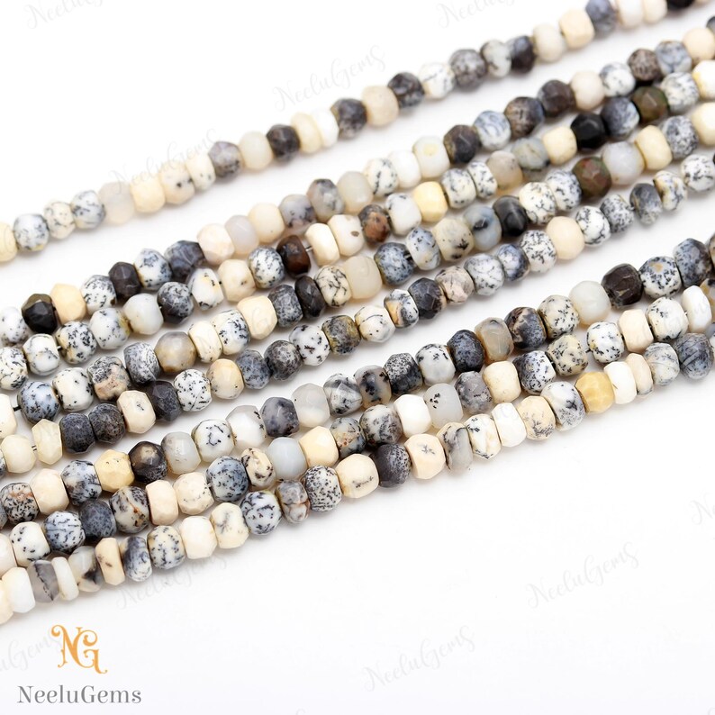 May include: A strand of white, gray, and brown gemstone beads. The beads are faceted and have a speckled pattern. The beads are strung on a clear thread.