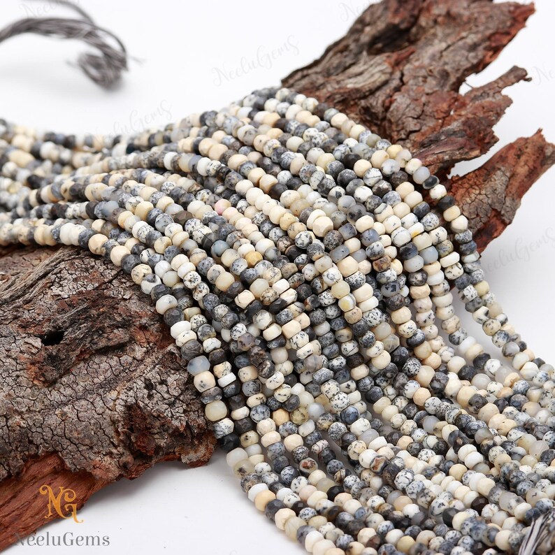May include: A strand of white and gray speckled gemstone beads. The beads are round and have a smooth, polished finish. The beads are strung on a clear thread and are ready to be used for jewelry making.