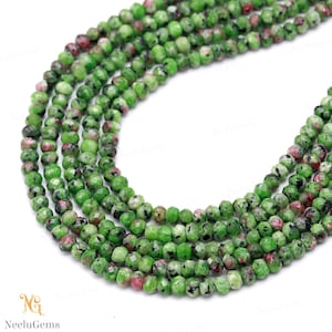 May include: Strands of faceted green and red gemstone beads. The beads are small, round, and have a polished, reflective surface. The gemstones are a mix of green, red, and black. The beads are strung together, ready for jewelry making.