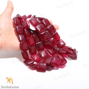 Op de afbeelding: Een streng dieprode vierkante edelsteen kralen. De kralen zijn doorschijnend en hebben een glanzende afwerking.