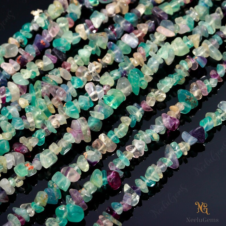 May include: A strand of multi-colored fluorite chip beads. The beads are a mix of green, blue, purple, and white. The beads are irregular in shape and size.