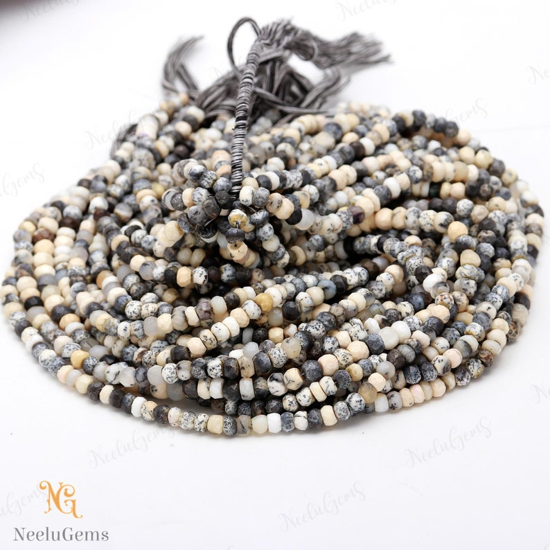 May include: A strand of small, round, white, gray, and black gemstone beads. The beads are approximately 4mm in diameter and have a speckled pattern. The beads are strung on a thin, clear thread.