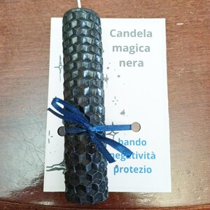 Può includere: Una candela nera a nido d'ape con un nastro blu legato intorno. La candela è etichettata "Candela magica nera" e "bando negativita protezio".