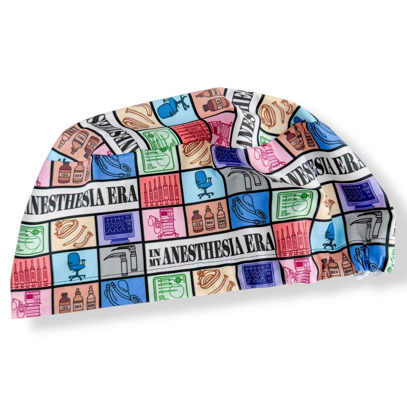 May include: A colorful surgical scrub cap with a repeating pattern of medical equipment and the text "IN MY ANESTHESIA ERA". The cap features a variety of colors including pink, blue, green, and yellow.