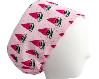 May include: A pink scrub cap featuring a repeating pattern of watermelon slices with black cat illustrations. The watermelon slices are red with black seeds and green rinds. The cats have black bodies and yellow eyes. The background is dotted with small black dots.